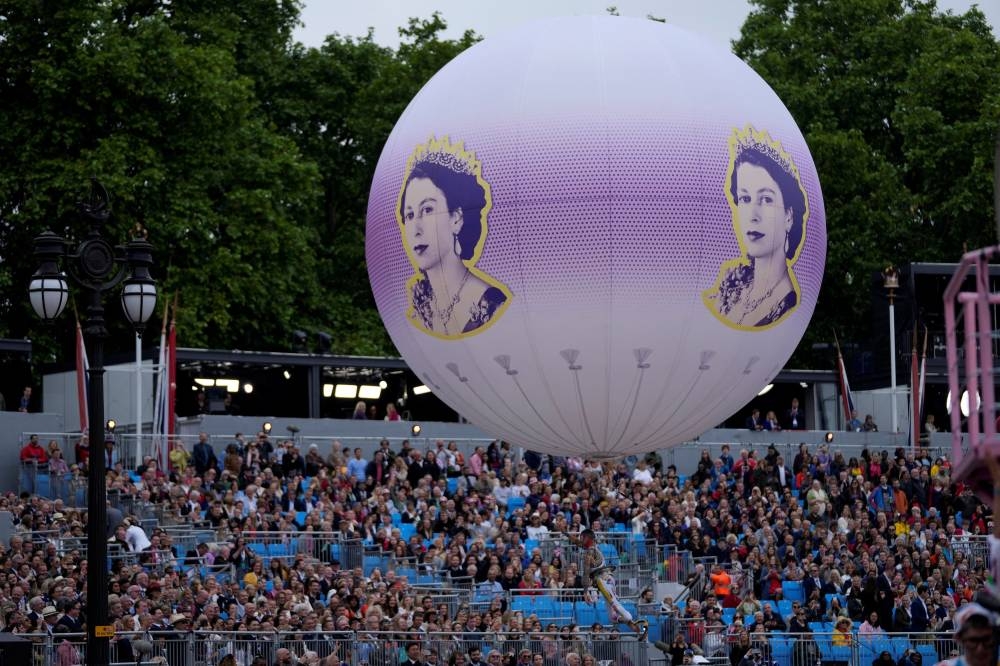 Spectators attend the Platinum Jubilee Pageant, marking the end of the celebrations for the Platinum Jubilee of Britain's Queen Elizabeth, outside Buckingham Palace, in London June 5, 2022.— Frank Agustein/Pool via Reuters     