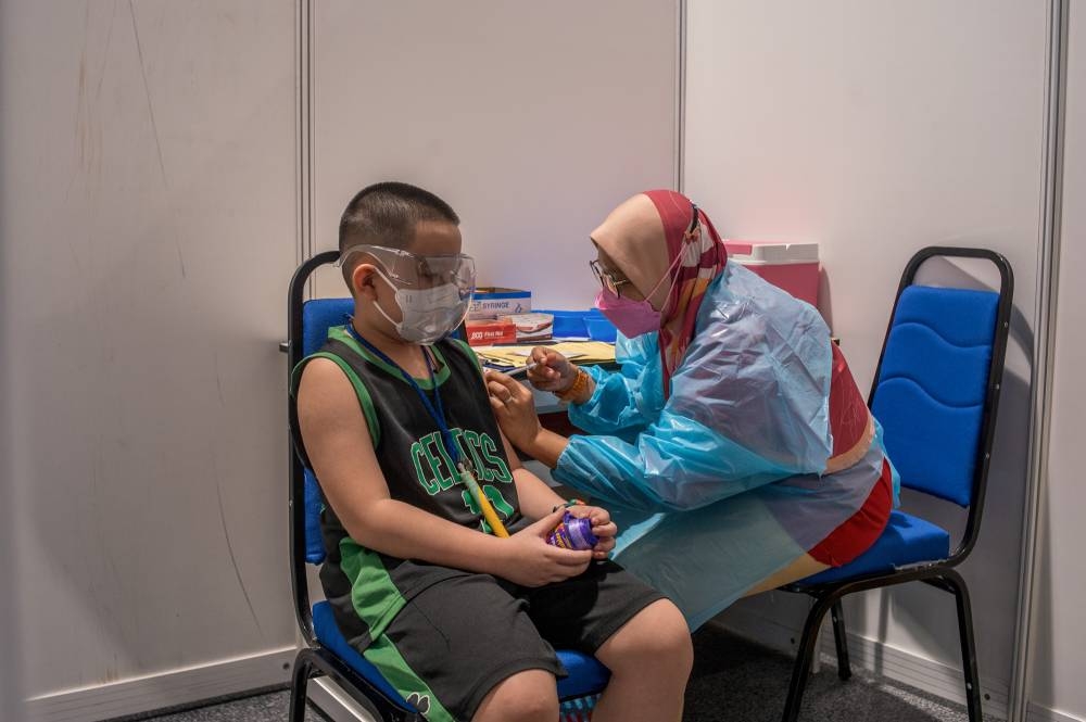 Children aged between five and 12 get their Covid-19 vaccine at the Axiata Arena in Bukit Jalil February 3, 2022. — Picture by Shafwan Zaidon