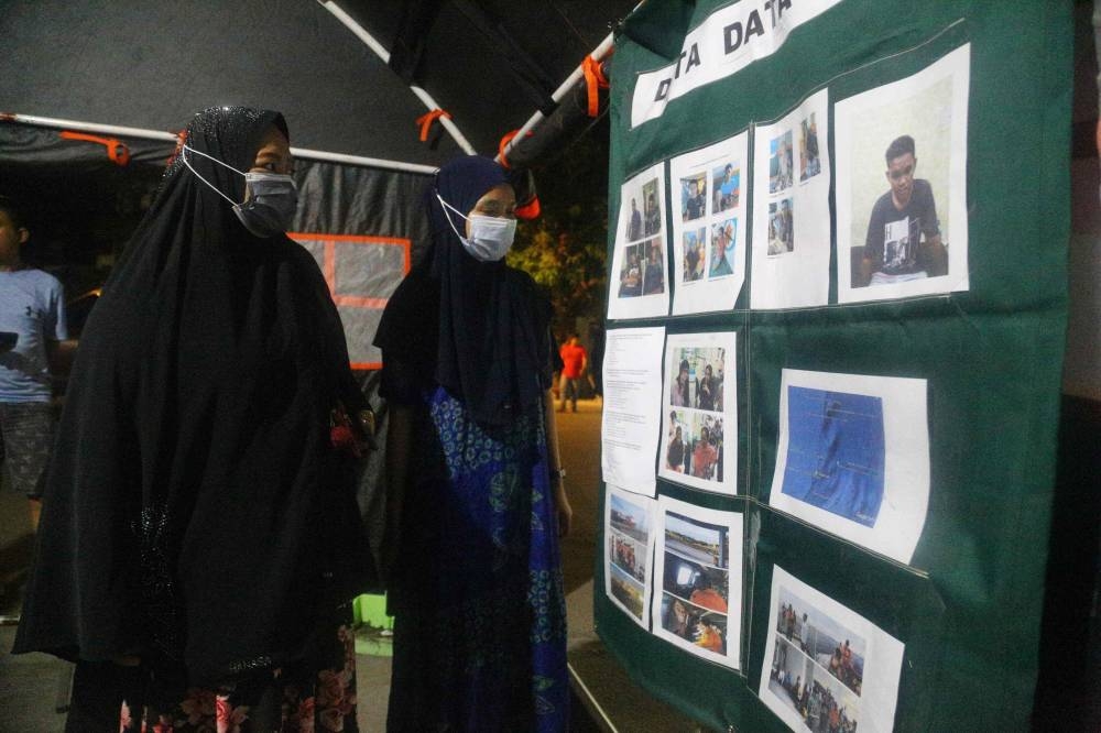 This picture taken on May 30, 2022 shows relatives of victims of the Ladang Pertiwi 02 ferry looking for informations about their missing family members at a search and rescue post in Makassar, South Sulawesi. — AFP pic