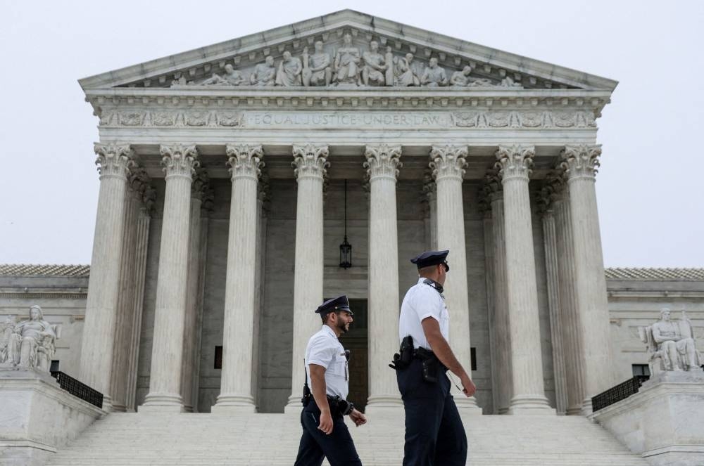 Police officers walk outside the U.S. Supreme Court in Washington May 3, 2022. — Reuters pic