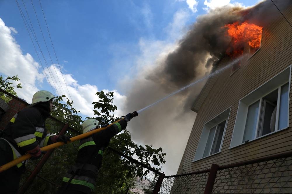 Firefighters try to extinguish a fire following a military strike, amid Russia's attack on Ukraine, at a residential area in Kharkiv, Ukraine June 7, 2022. — Reuters pic
