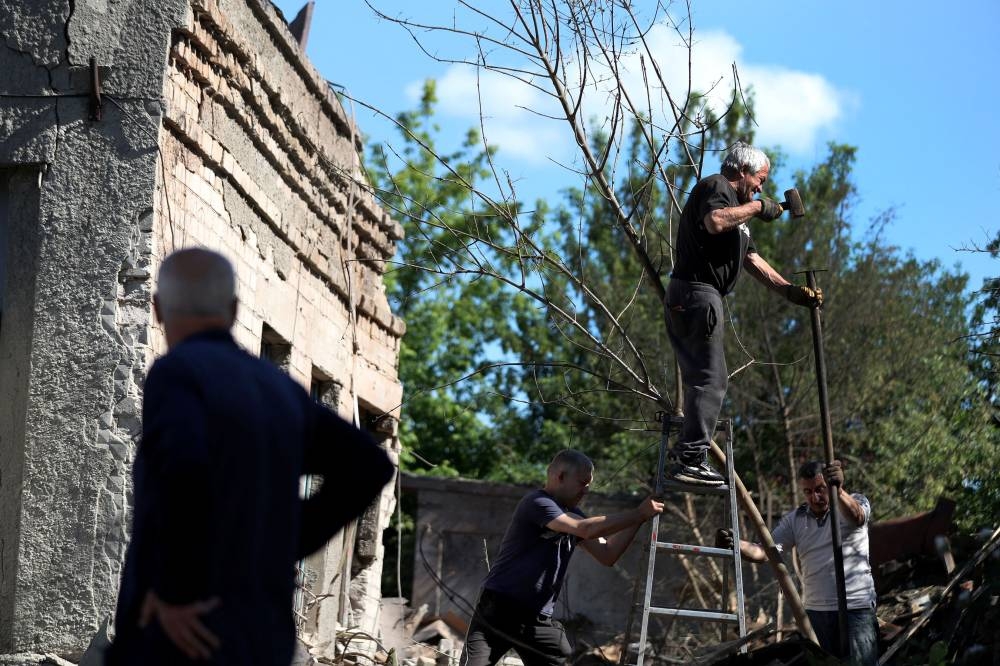 Local residents work at a damaged house following a last night military strike, amid Russia's attack on Ukraine, at a residential area in Kharkiv, Ukraine June 7, 2022. — Reuters pic