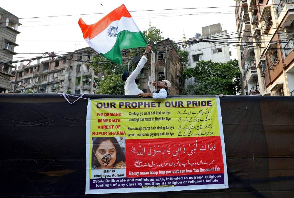 People hold aloft the national flag of India before the start of a protest demanding the arrest of BJP member Nupur Sharma for her blasphemous comments on Prophet Mohammed, in Kolkata June 7, 2022. — Reuters pic