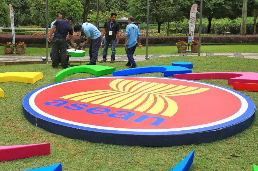 Workers are pictured getting the Asean logo ready at the Kuala Lumpur Convention Centre, November 17, 2015. — Picture by Saw Siow Feng