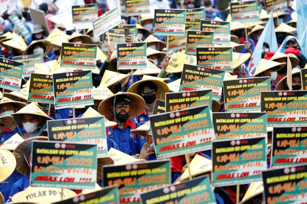 Members of Indonesian trade unions hold placards during a protest against the government's labour reforms, as Indonesia's Constitutional Court reads the verdict on a judicial review filed on the controversial 'omnibus' or job creation law in Jakarta, Indonesia November 25, 2021. ― Reuters file pic