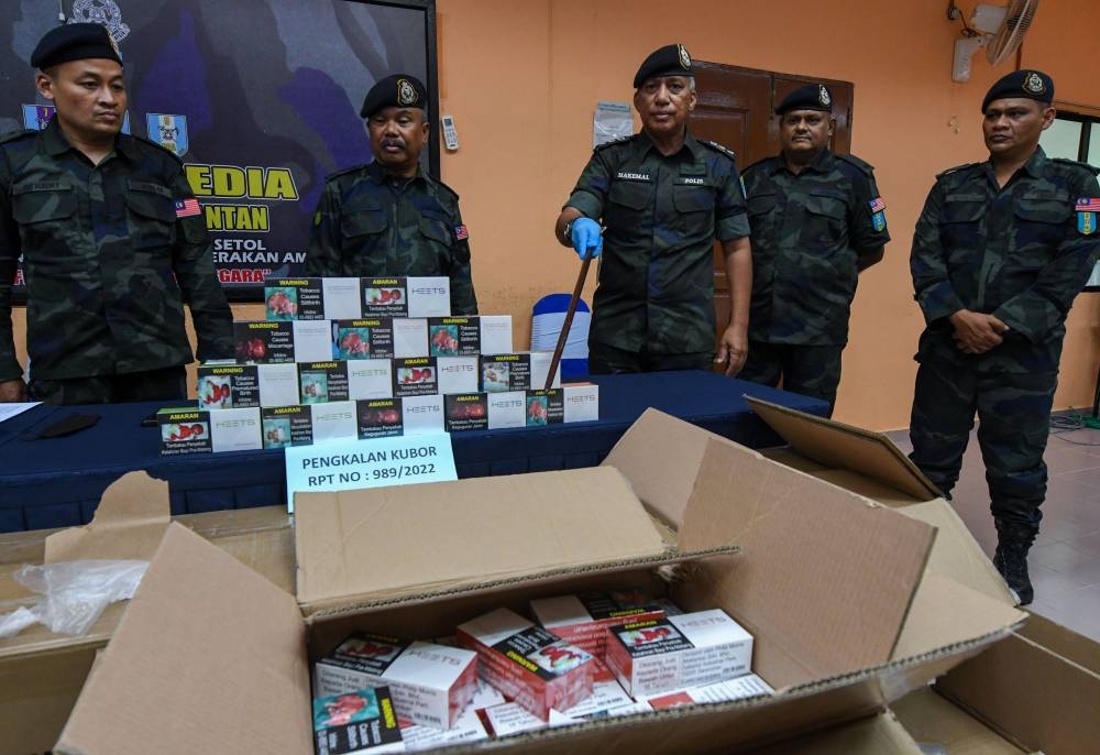 GOF Southeast Brigade deputy commander ACP Hakemal Hawari (centre) along with other officers show a portion of the e-cigarettes and vape liquid worth RM1.4 million seized at two locations in Tumpai June 12, 2022. — Bernama pic