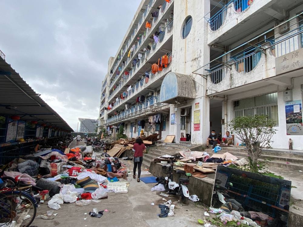 A woman walks by port workers' accommodation building that is to be demolished, in the Shekou area of Shenzhen, Guangdong province June 11, 2022. — Reuters pic