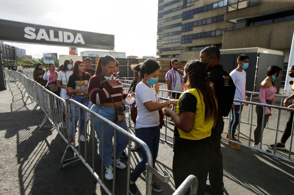 People show their tickets at a checkpoint during an urban music festival housed in the open parking lot of a shopping centre in Caracas, Venezuela June 4, 2022. — Reuters pic