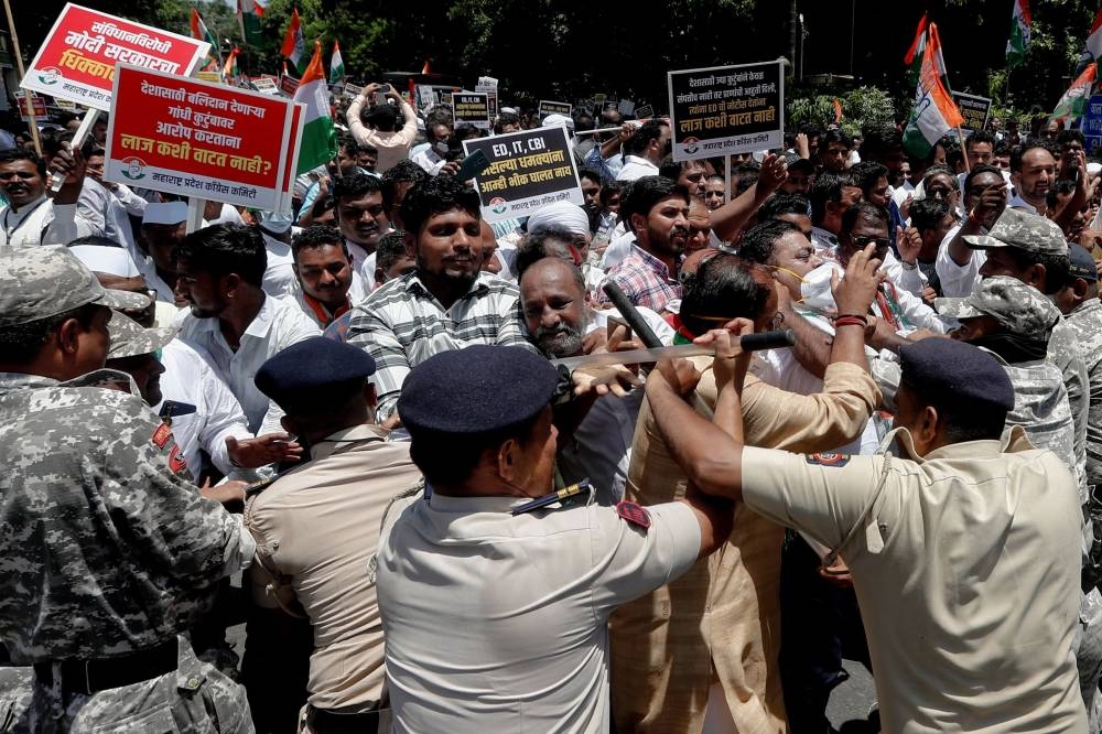 Police officers block supporters of India's main opposition Congress party during a protest after the party's former leader Rahul Gandhi was summoned by the Enforcement Directorate in a money laundering case, in Mumbai, India, June 13, 2022. — Reuters pic