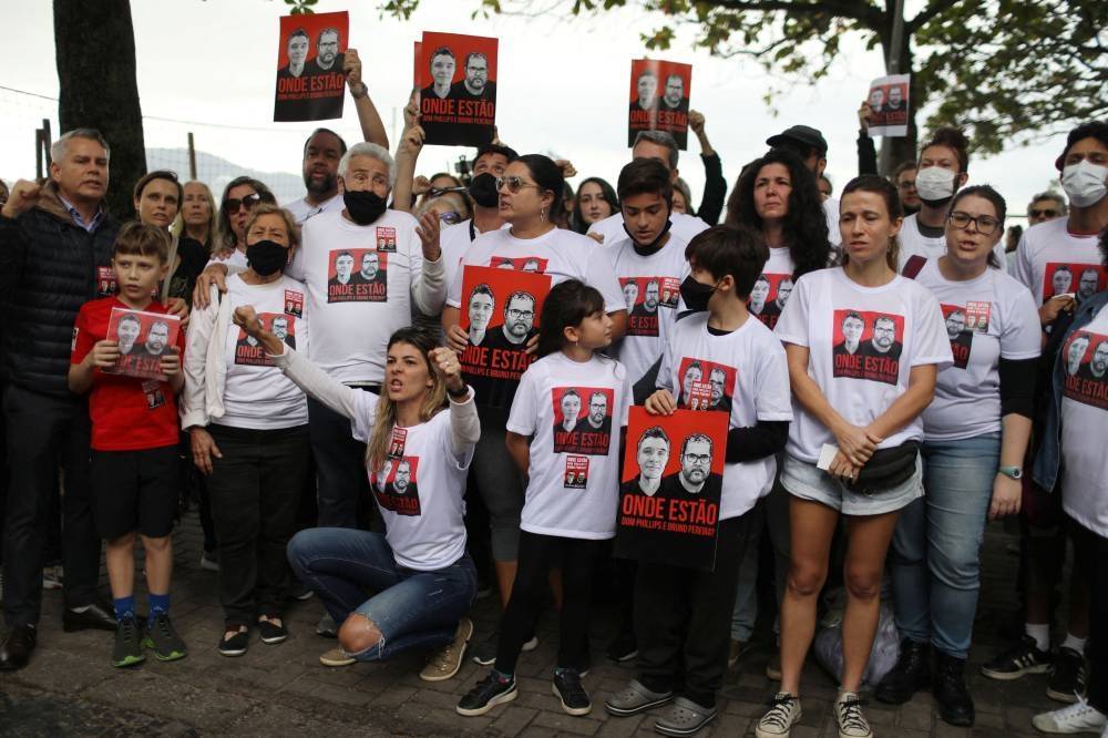 Relatives and friends of British journalist Dom Phillips' wife hold placards during a protest following the Amazon disappearance of Phillips and indigenous expert Bruno Araujo Pereira, at Copacabana beach, Rio de Janeiro June 12, 2022. — Reuters pic