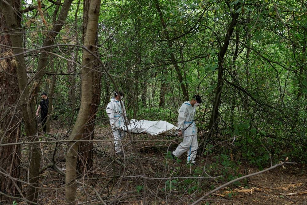Forensic technicians carry a body of a person who, Ukrainian police say, was killed and buried at a position of Russian troops during Russia’s invasion, near the village of Vorzel in Bucha district, Kyiv region, Ukraine June 13, 2022. — Reuters pic