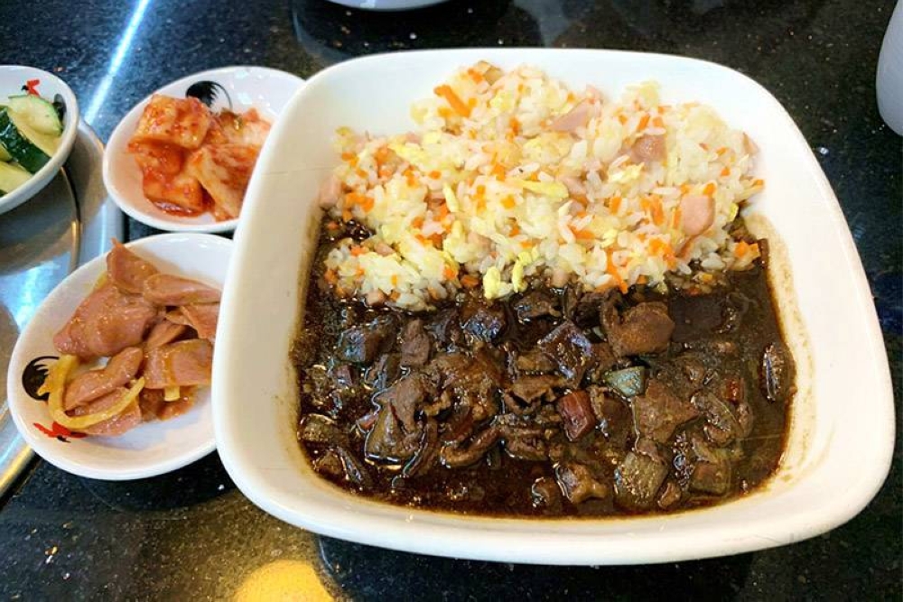 A big plate of 'jjajang' fried rice with banchan (side dishes).