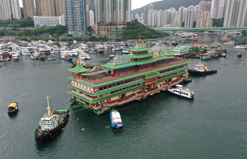 An aerial photo shows Hong Kong's Jumbo Floating Restaurant, an iconic but aging tourist attraction designed like a Chinese imperial palace, being towed out of Aberdeen Harbour on June 14, 2022, after its popularity dimmed in recent years even before the coronavirus hit. — AFP pic