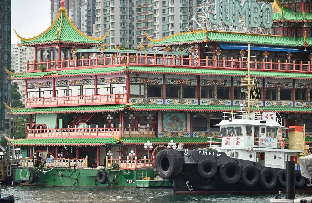 A tugboat pulls up beside Hong Kong's Jumbo Floating Restaurant, an iconic but aging tourist attraction designed like a Chinese imperial palace, before being towed out of Aberdeen Harbour on June 14, 2022, after years of revitalisation efforts went nowhere. — AFP pic