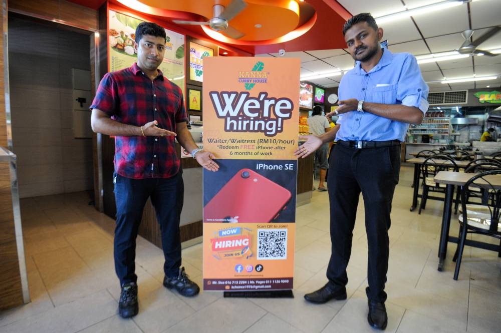 Kanna Curry House manager, Yoga Kannan (left) and general manager, Siva with their offer to Malaysians to fill vacancies. — Picture by Shafwan Zaidon