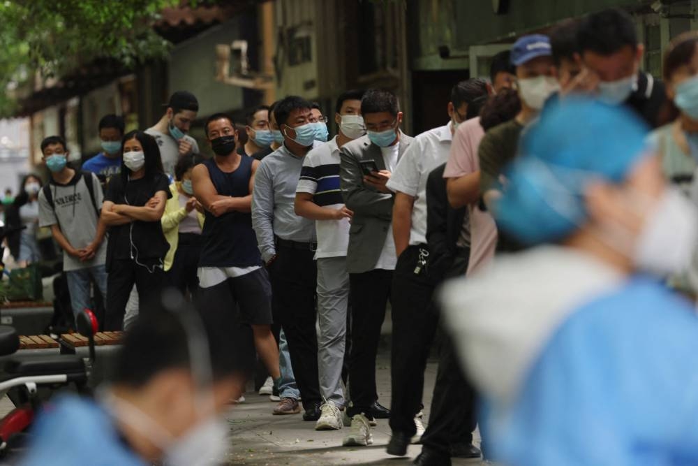 People line up for nucleic acid test at a mobile testing booth, following the coronavirus disease (Covid-19) outbreak, in Beijing June 13, 2022. — Reuters pic