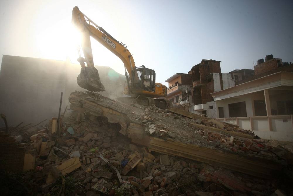 A bulldozer demolishes the house of a Muslim man that Uttar Pradesh state authorities accuse of being involved in riots last week, that erupted following comments about the Prophet Mohammed by India's ruling Bharatiya Janata Party (BJP) members, in Prayagraj, India, June 12, 2022. Authorities claim the house was illegally built. — Reuters pic