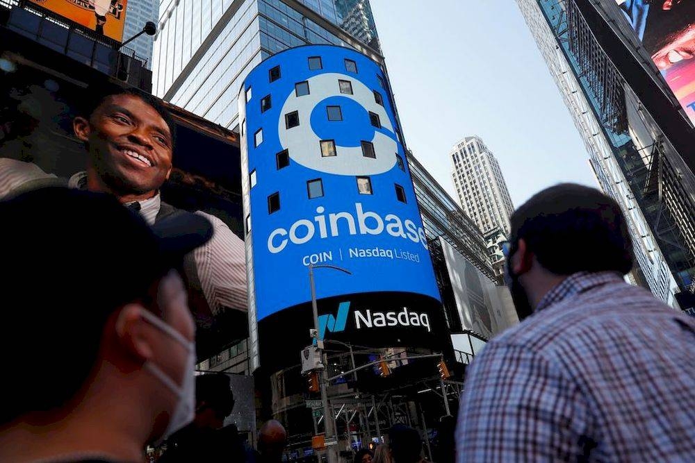 People watch as the logo for Coinbase Global Inc, the biggest US cryptocurrency exchange, is displayed on the Nasdaq MarketSite jumbotron at Times Square in New York April 14, 2021. — Reuters pic