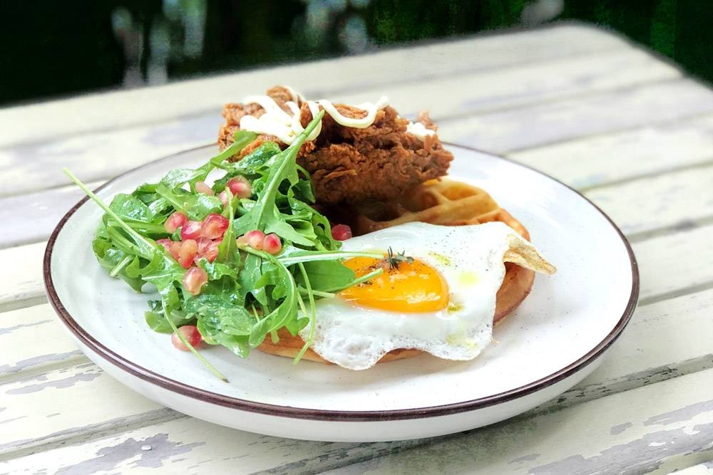 Buttermilk fried chicken and Belgian waffle, topped with a sunny side up.