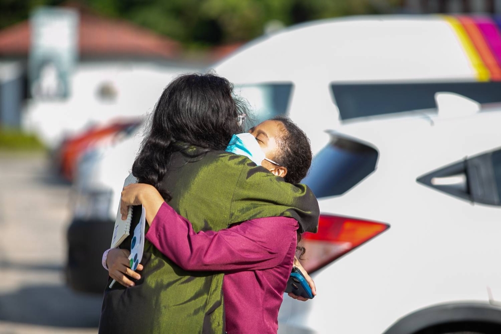 Students are greeted by their classmates, family members, and friends at SMK (P) Sri Aman in Petaling Jaya, June 16, 2022. — Picture by Devan Manuel