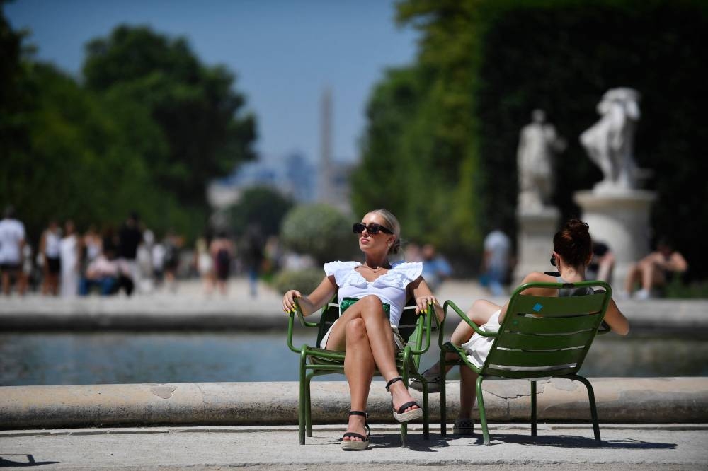 Women take a sunbath in the Jardin des Tuilerie amid high temperatures in Paris on June 16, 2022. ― AFP pic
