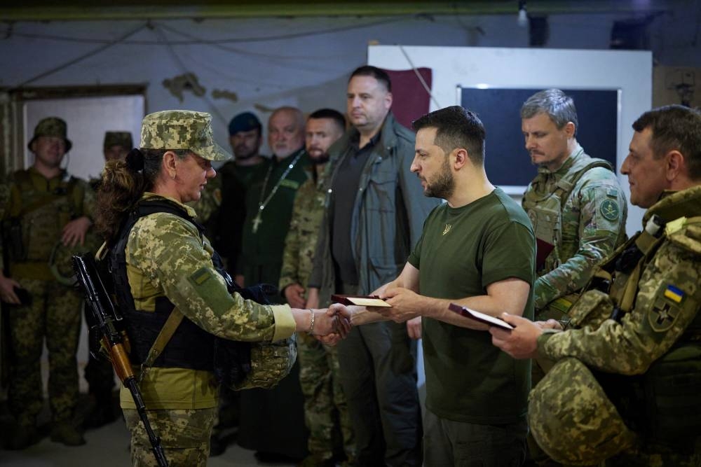 Ukraine’s President Volodymyr Zelenskiy awards a Ukrainian servicewoman at a position, as Russia’s attack on Ukraine continues, outside the southern city of Mykolaiv, Ukraine June 18, 2022. ― Reuters pic
