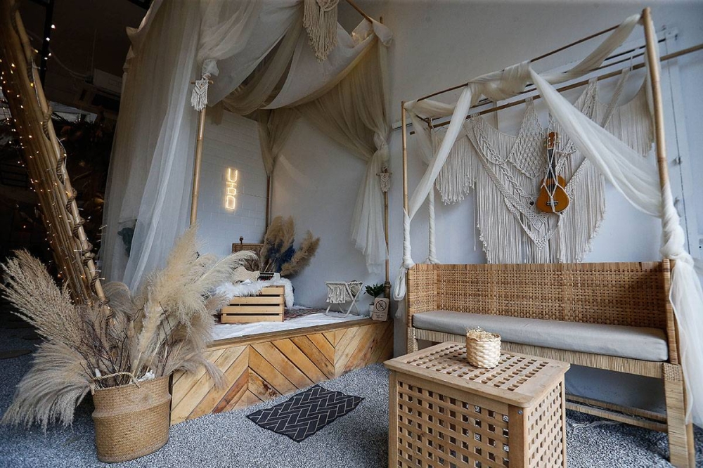 La entrada del café es única, con una pasarela de guijarros y un arco de bambú que lleva a los visitantes al interior, a un espacio bañado por el sol decorado en tonos beige y crema apagados.  — Foto de Sayutya Zainudin