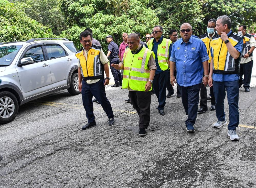 Perak Mentri Besar Datuk Seri Saarani Mohamad (2nd left) and Senior Works Minister Datuk Seri Fadillah Yusof (right) inspect the condition of the road at Jalan Gerik-Jeli in Gerik June 20, 2022. — Bernama pic
