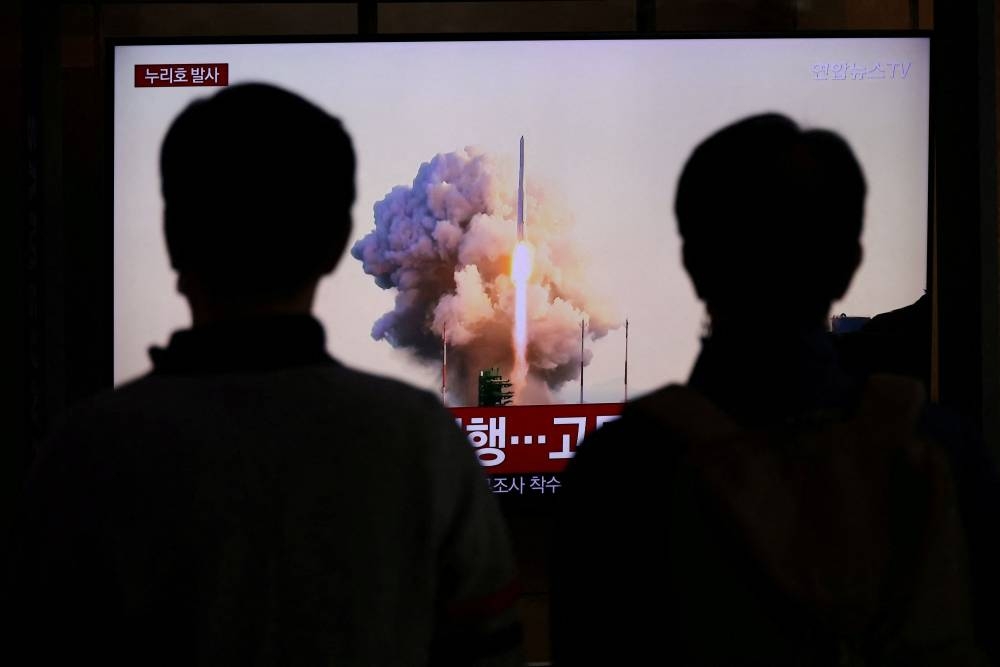 People watch a TV broadcasting a news report on the KSLV-II NURI rocket launching from its launch pad of the Naro Space Center, at a railway station in Seoul, South Korea October 21, 2021. ― Reuters file pic