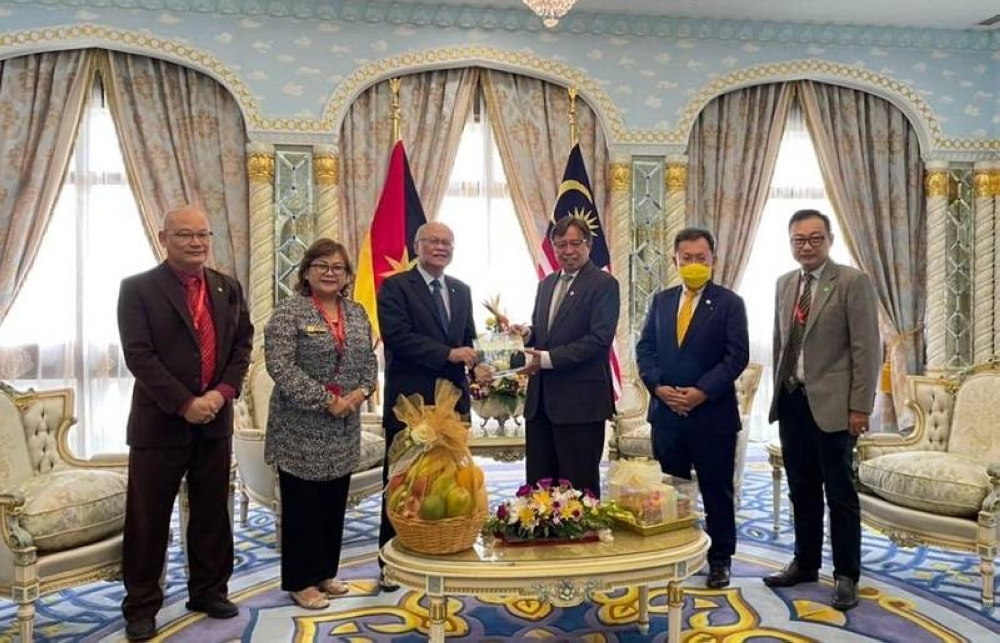 Minos (third left) presents the invitation to Abang Johari. Dr Sim is at second right. — Borneo Post Online pic