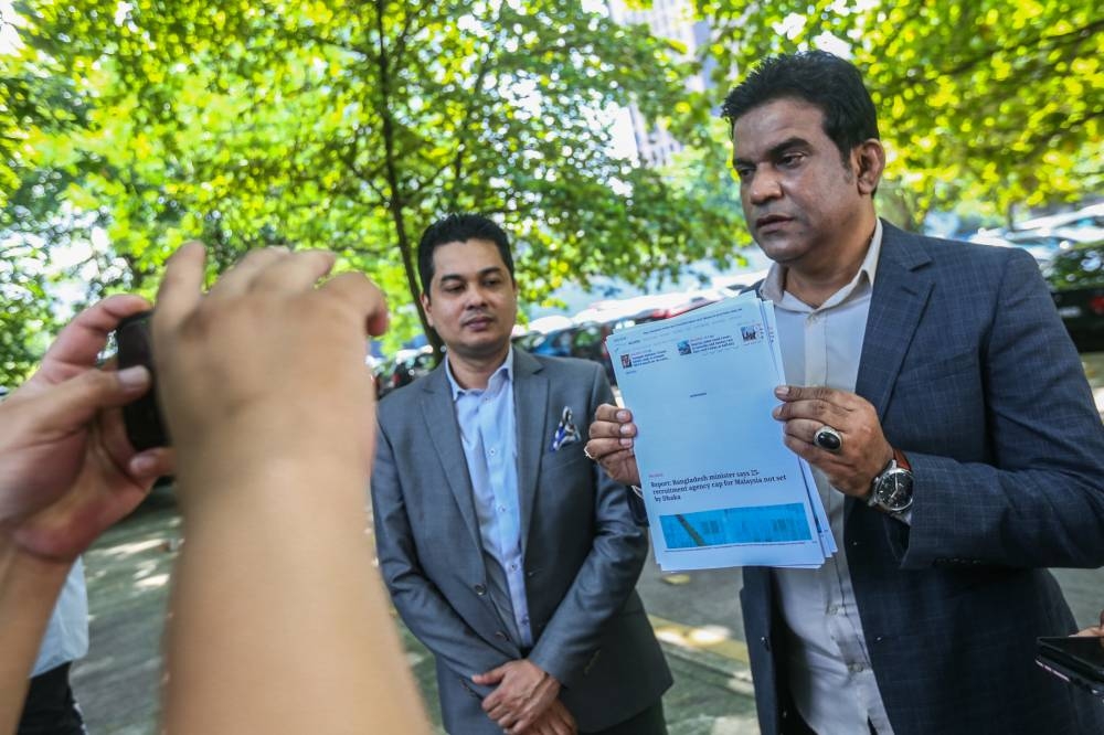 Ikhlas president Mohd Ridzuan Abdullah (right) speaks to the media after making a police report against the human resources minister at Dang Wangi police station June 21, 2022. — Picture by Hari Anggara