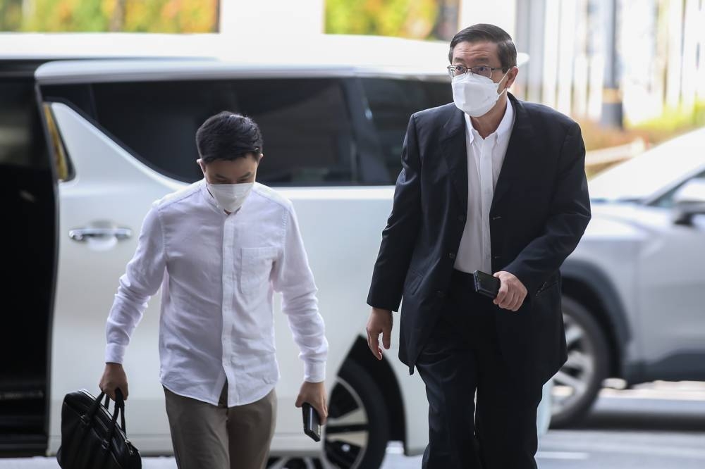 Lim Guan Eng (right) arrives at the Kuala Lumpur High Court June 23, 2022. — Picture by Ahmad Zamzahuri
