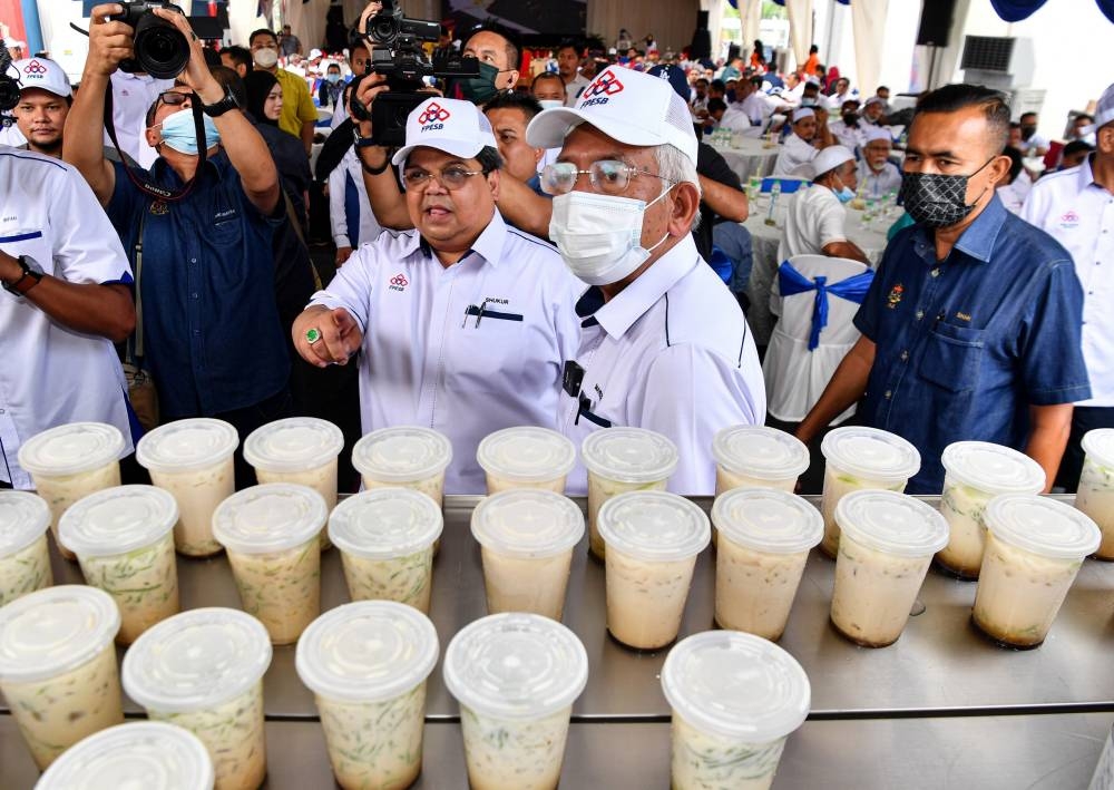 Rural Development Minister Datuk Seri Mahdzir Khalid (2nd right) looks at cendol made from palm oil milk or santan after the official opening of the Felcra Processing & Engineering Sdn Bhd industrial complex in Teluk Intan June 23, 2022. — Bernama pic