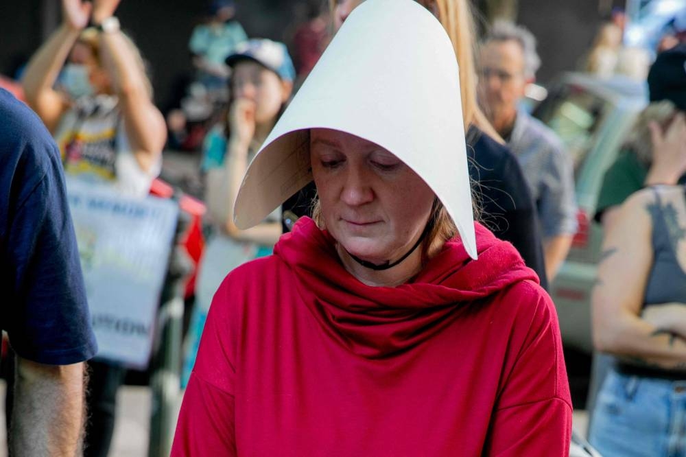 A woman dressed as a character from The Handmaid Tale and abortion rights activists protest after the US Supreme Court struck down Roe Vs. Wade, overturning the right to abortion, in Portland, Oregon, on June 24, 2022. — AFP pic