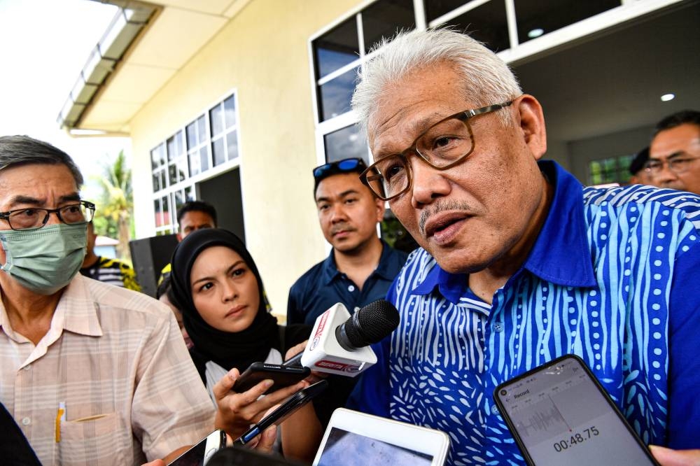 Home Minister and Larut Member of Parliament, Datuk Seri Hamzah Zainudin (right) talking to reporters after attending a Kampung Anak Kurau program in Batu Kurau, June 25, 2022. — Bernama pic