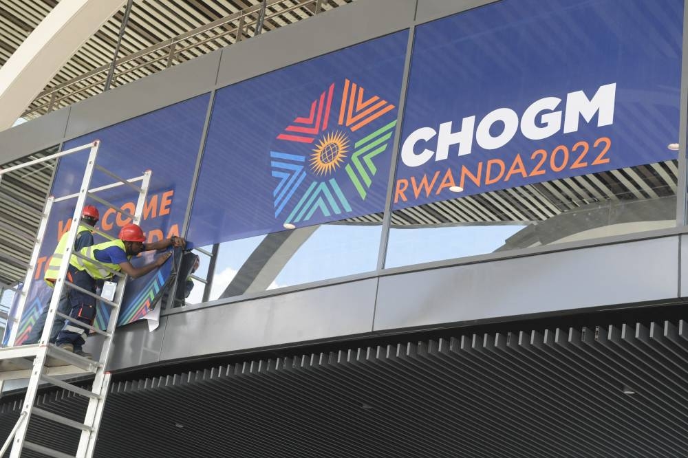 Workers are seen applying signage at the Kigali Convention Centre on June 21, 2022, the venue hosting the Commonwealth Heads of Government Meeting (CHOGM) till June 26th. — AFP pic