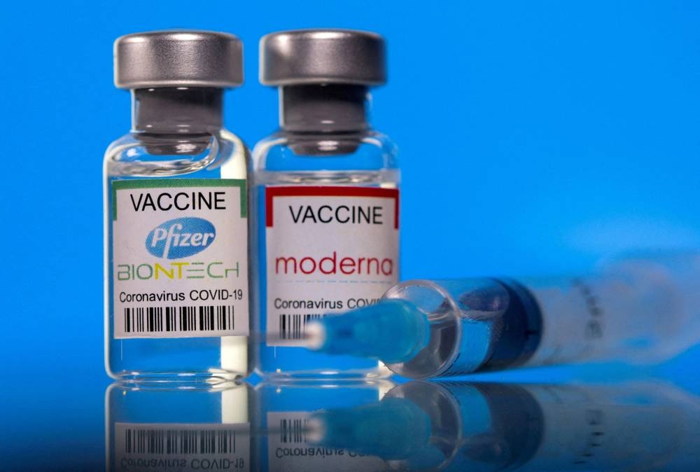 Vials with Pfizer-BioNTech and Moderna coronavirus vaccine labels are seen in this illustration picture taken March 19, 2021. — Reuters pic