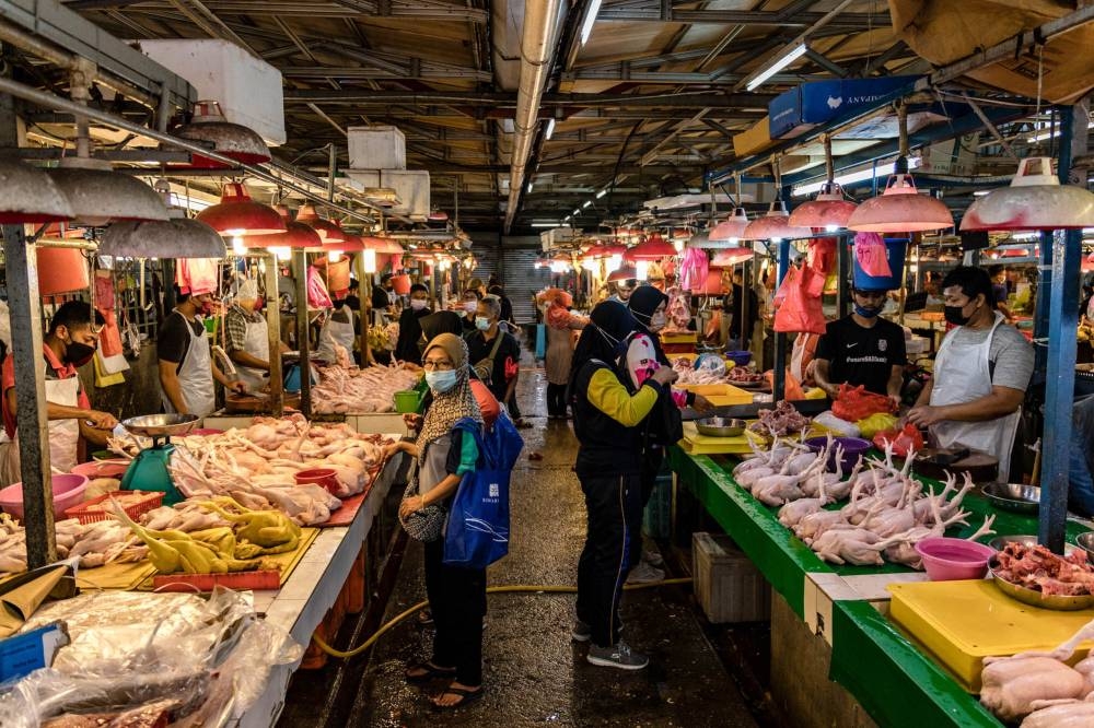 A customer waits to buy chicken meat at a wet market in Chow Kit, Kuala Lumpur February 3, 2022. — Picture by Firdaus Latif