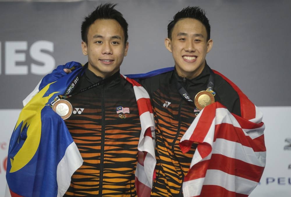 KUALA LUMPUR,27/08/2017. Gold medalists Ooi Tze Liang (R) and Silver medallists Chew Yiwei of Malaysia celebrate on the podium during the medal ceremony for Men's Diving 10m plaform final on day 14 of the SEA Games 2017 at National Aquatic Centre in Bukit Jalil   Malay Mail/Firdaus Latif