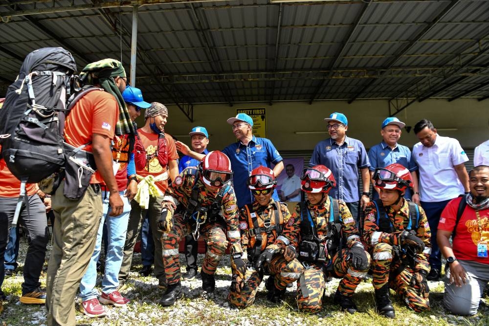 Energy and Natural Resources Minister Datuk Seri Takiyuddin Hassan with members of the Perak Fire and Rescue Department’s multi skill team in Kampar, June 27, 2022. — Bernama pic     