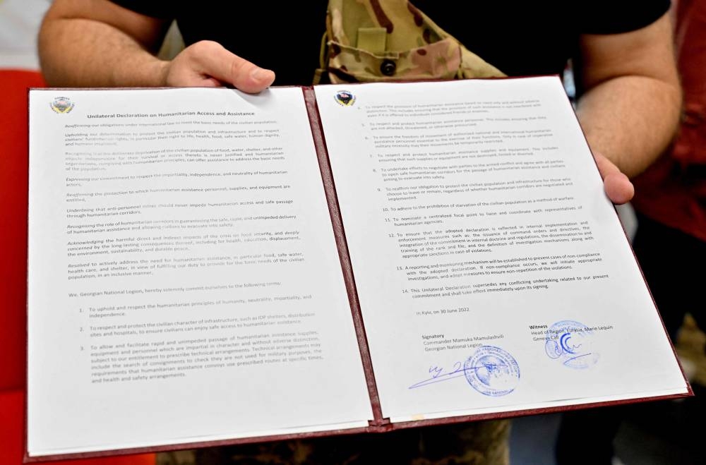 Head of the Georgian National Legion Mamuka Mamulashvili holds a folder with an agreement to observe international norms signed after a presentation organised by a Swiss NGO called Geneva Call in Kyiv on June 30, 2022 as a part of its efforts to meet and provide guidance to a wide range of Ukrainian combatants. ― AFP pic