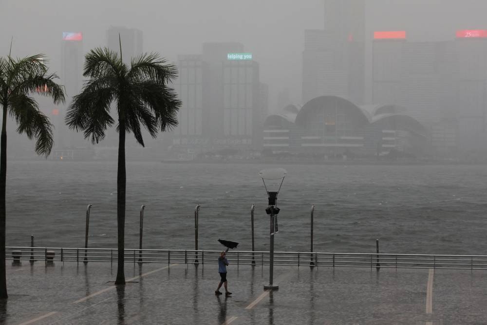 A man holds an umbrella in the rain at a waterfront, amid a typhoon warning on the 25th anniversary of the former British colony’s handover to Chinese rule, in Hong Kong, China July 1, 2022. ― Reuters pic