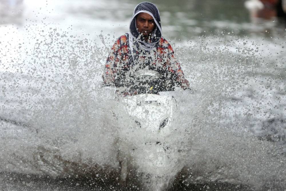 A person rides a scooter through a waterlogged road during monsoon rain showers in Mumbai, India, June 4, 2020. ― Reuters pic