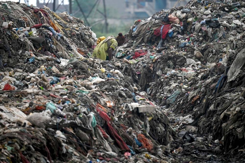 A woman look for recyclable materials at a dumping site in New Delhi on June 30, 2022. ― ETX Studio pic