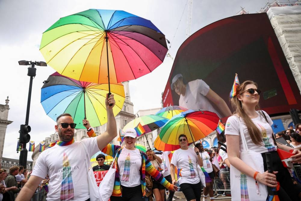 People hold rainbow coloured umbrellas during the 2022 Pride Parade in London, Britain July 2, 2022. ― Reuters pic
