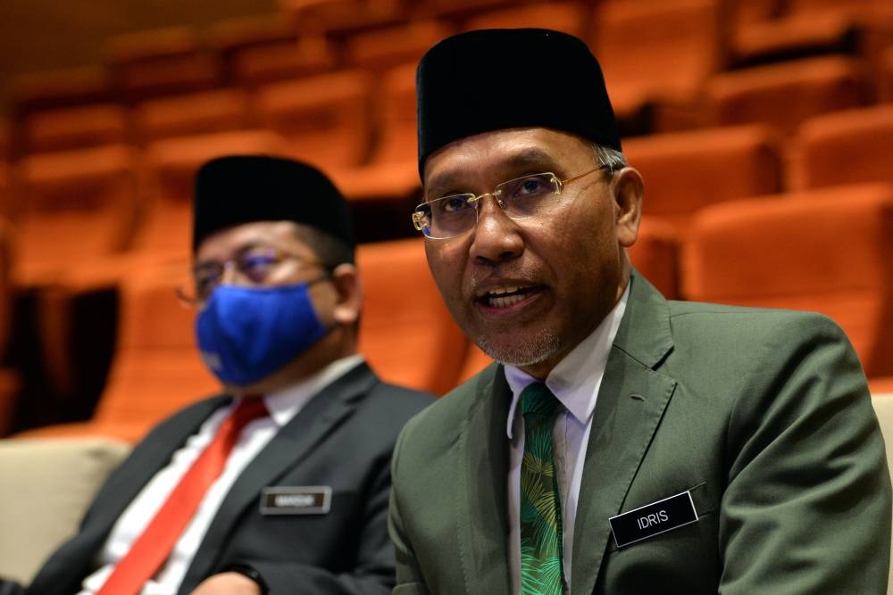 Minister in the Prime Minister’s Department (Religious Affairs) Senator Datuk Idris Ahmad (right) speaks during a press conference in Putrajaya June 27, 2022. — Bernama pic