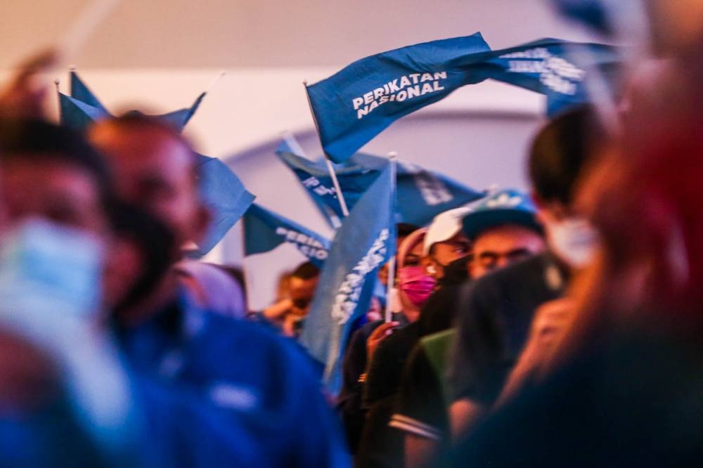 Perikatan Nasional (PN) party members waving a PN’s flag during the announcement of the candidates for the coalition’s Johor state election at Pulai Springs Resort February 24, 2022. — Picture by Hari Anggara