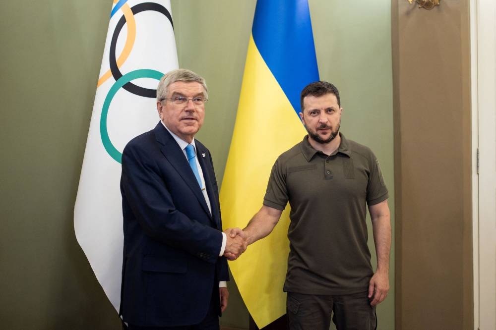 Ukrainian President Volodymyr Zelenskiy and President of the International Olympic Committee Thomas Bach shake hands during a parliament session in Kyiv, Ukraine July 3, 2022. — Reuters pic