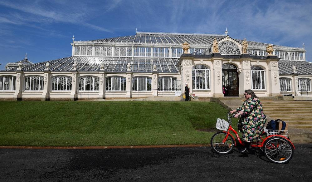 A visitor cycles past the Victorian Temperate House in Kew Gardens, London May 3, 2018. — Reuters pic