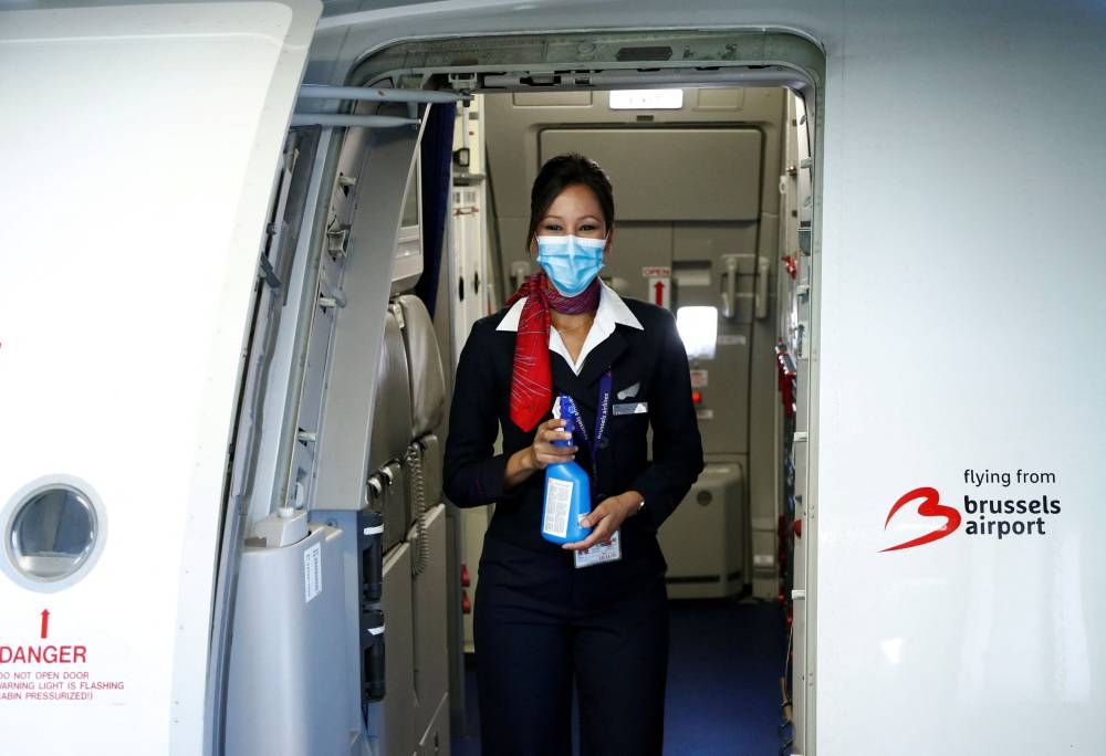 A flight attendant wearing a protective mask holds disinfectant spray onboard a Brussels Airlines aircraft before the take-off at the Zaventem International Airport, as Belgium eases restrictions aimed to contain the spread of the coronavirus disease (Covid-19) outbreak, near Brussels June 15, 2020. — Reuters pic